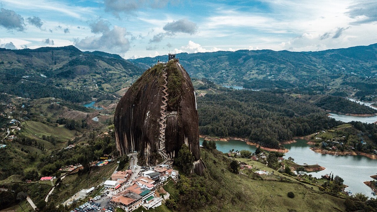 The giant Rock of Guatapé with its zigzag staircase, beside a blue reservoir and green hills
