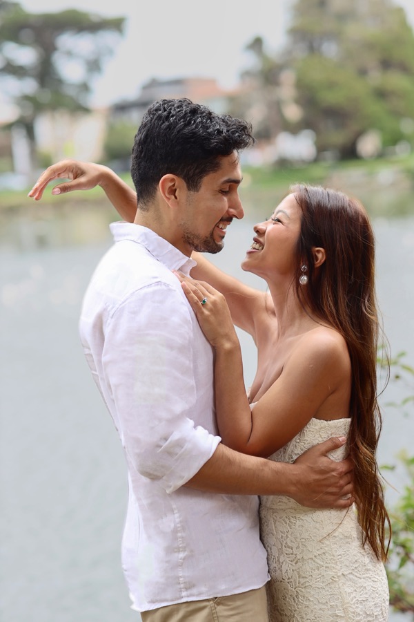 Trinique and Juan Pablo embracing by the water, smiling at each other